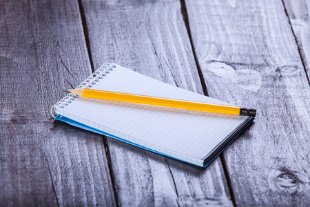 Notebook and pencil on wooden table.の写真素材
