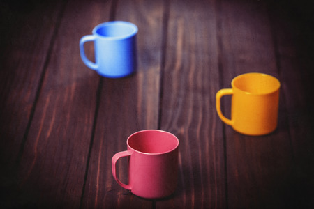 Three color cups on wooden tableの写真素材