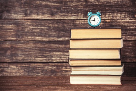 Alarm clock and books on wooden table.の写真素材