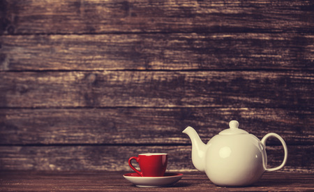 Teapot and cup of tea on wooden table.の写真素材