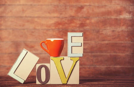 Tea or coffee cup with word Love on wooden table.の写真素材