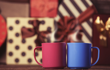 Two cup of coffee and holidays gifts on background.の写真素材