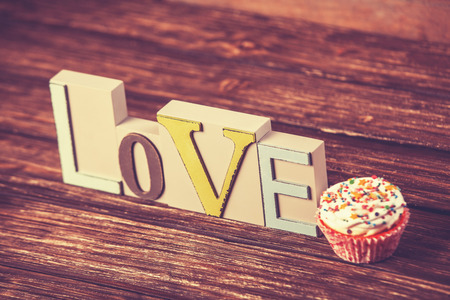 Cupcake and word Love on wooden table.の写真素材