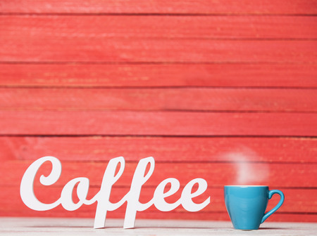 Abstract wooden word Coffee with cup on red wooden background.の写真素材