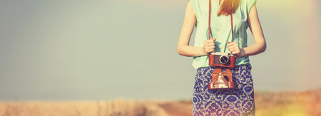 	girl with camera on country sideの写真素材