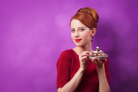 Redhead women with candy on violet background.の写真素材
