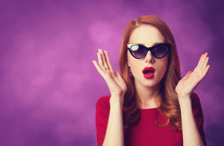 Beautiful redhead women on viloet background.