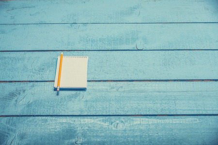 notebook with pencil on blue wooden table
