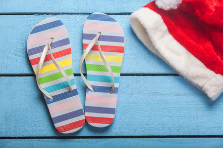 beach slippers and christmas hat on blue woodの写真素材