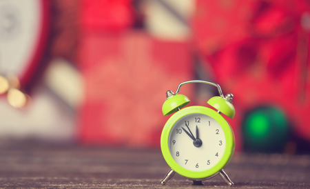 Little alarm clock and gift on background.