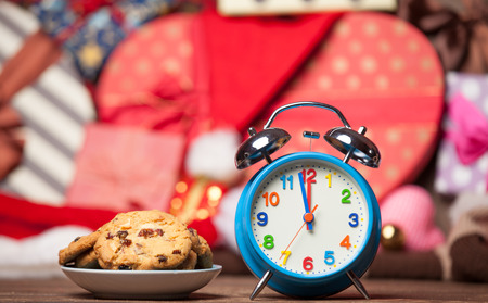 Retro alarm clock with cookie on a table. Photo in retro color image styleの写真素材