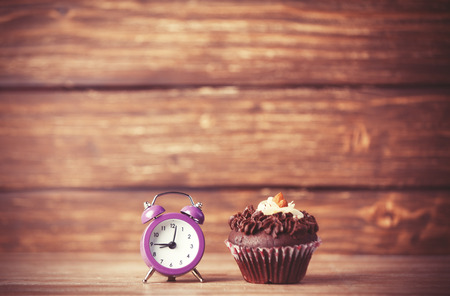 Alarm clock and cupcake.