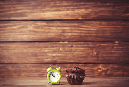 Alarm clock and cupcake.の写真素材