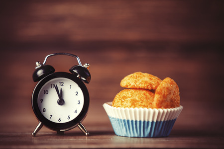 Alarm clock and cupcake.の写真素材