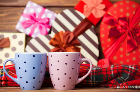Two cup of coffee and holidays gifts on background.の写真素材