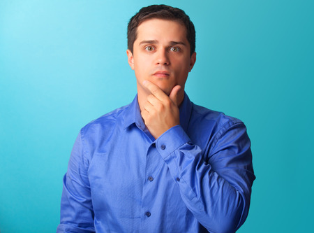 Surprised man in shirt on blue background.