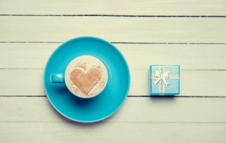 Cup of coffee and gift on wooden table.の写真素材