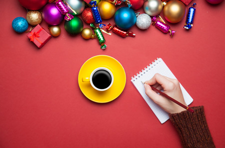 hand writing something in to the notebook near christmas toys.の写真素材