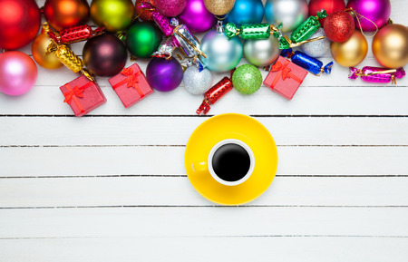 Coffee cup and christmas toys on white background.