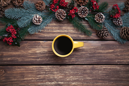 Hot coffee on wooden table near pine branchesの写真素材