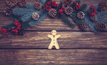 Gingerbread man on a table near pine branchesの写真素材