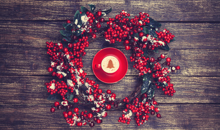Holly christmas wreath on wooden table.の写真素材