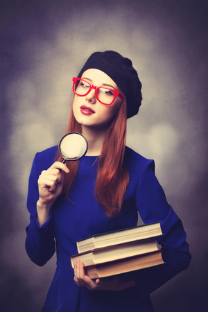Portrait of beautiful girl in blue dress with books and bokeh on background.の写真素材