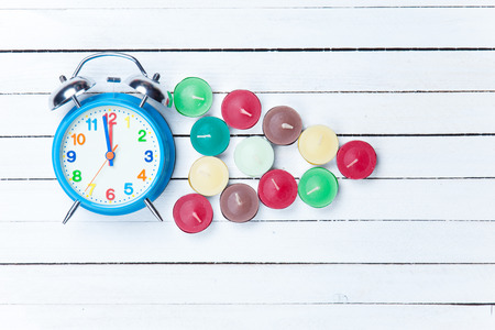 Retro alarm clock and candles on white backgroundの写真素材