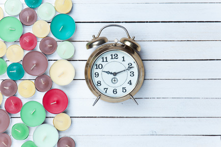 Retro alarm clock and candles on white backgroundの写真素材