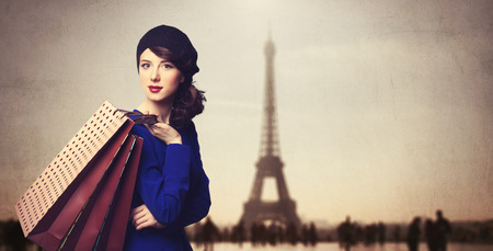 Portrait of beautiful women in blue dress with shopping bags on Parisian background.の写真素材
