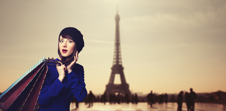 Surprised women in blue dress with shopping bags on parisian background.の写真素材