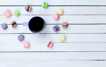 Cup of coffee and macarons on white wooden backgroundの写真素材