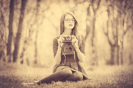 Beautiful women with camera in the park.  Photo in old color image style.の写真素材