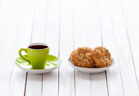 Cup of coffee and cookies on white wooden backgroundの写真素材