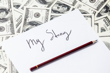 pencil and paper with My Story words and one hundred dollar bills