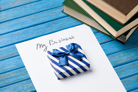 Gift boxes, books, pencil and paper with My Business words on blue background