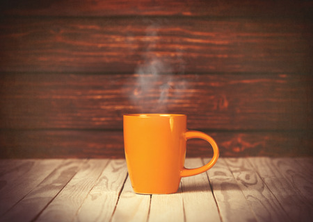 Cup of coffee on wooden table and background. Photo in old color image styleの写真素材
