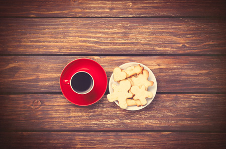 Cup of coffee and cookies on woden background. Photo in old color image style.の写真素材