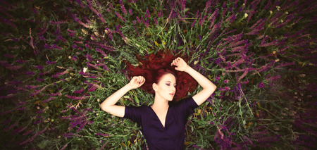 Portrait of a beautiful redhead girl on lavender field. View above.の写真素材
