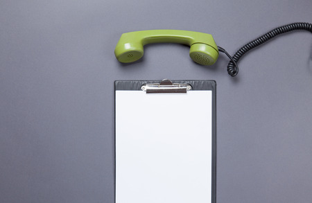 Business board and green handset on grey backgroundの写真素材