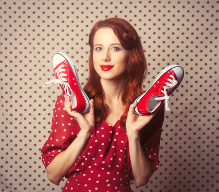 Portrait of redhead girl with gumshoes on Polka dot background.の写真素材