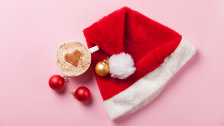 Cup of coffee with heart shape and christmas toys on pink background.の写真素材