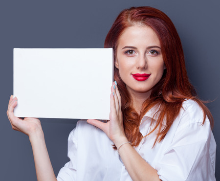 Portrait of a businesswomen in white shirt with board on grey background.の写真素材
