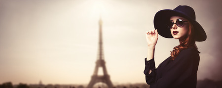 Style redhead women with sunglasses on Eiffel tower backgroundの写真素材