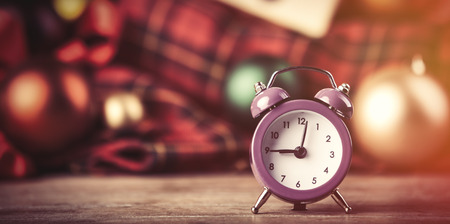 Alarm clock and christmas gifts on background.