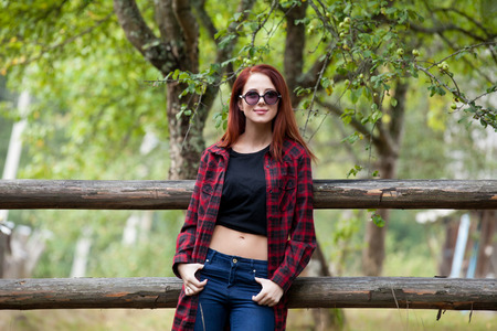 Portrait of a redhead women near the fence at outdoorの写真素材