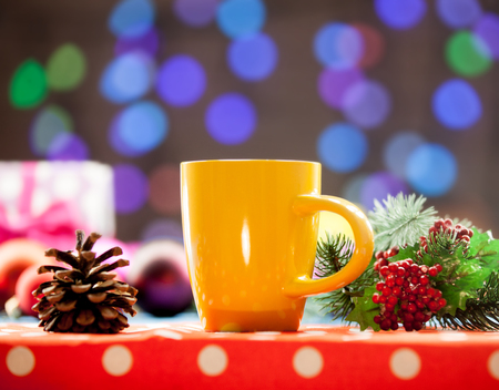 Cup of tea and branch with Christmas lights on background.の写真素材