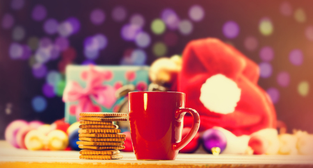 Cup of tea or coffee and cookies on Christmas backgroundの写真素材