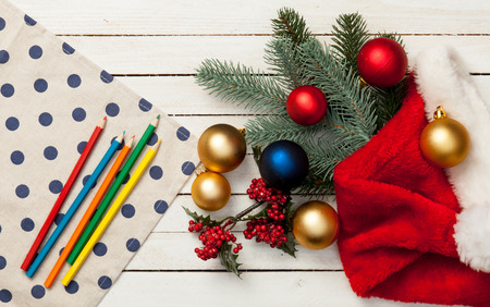 Napkin and pencils with baubles on white wooden table.の写真素材