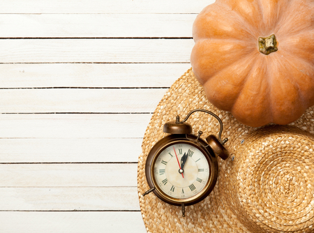 Pumpkin and hat with leafs on white wooden tableの写真素材
